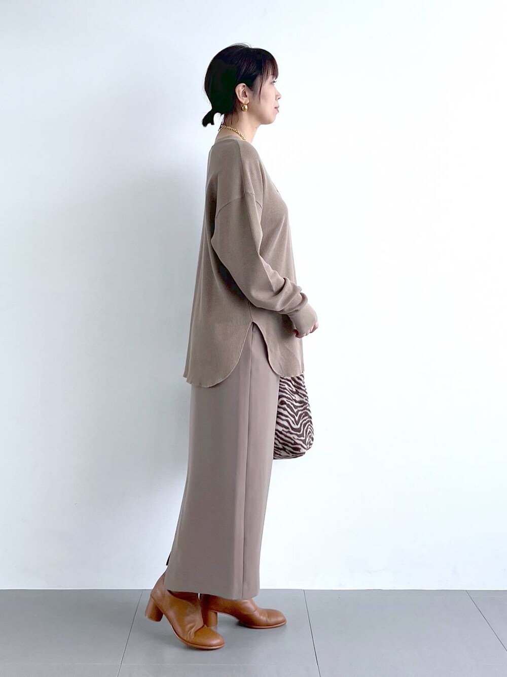 ブラウン系のスカート、イエロー系のブーツ、その他のトートバッグを着用したレディースの秋コーディネートの9枚目の写真