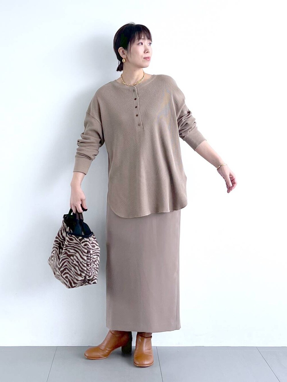 ブラウン系のスカート、イエロー系のブーツ、その他のトートバッグを着用したレディースの秋コーディネートの5枚目の写真