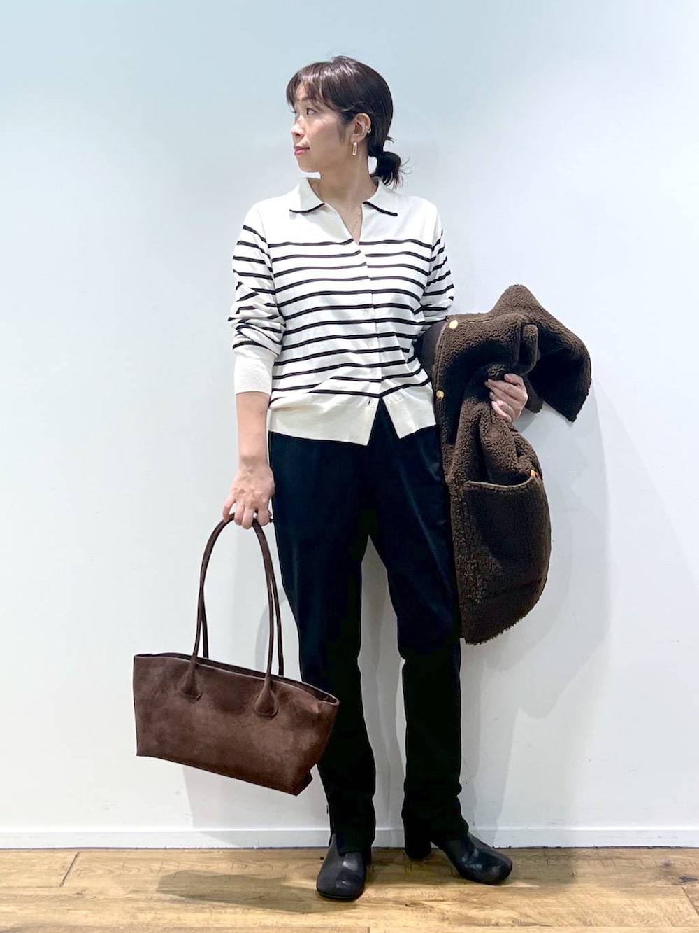 ブラック系のその他パンツ、ホワイト系のニット/セーター、その他のピアス(両耳用)を着用したレディースの秋コーディネートの3枚目の写真