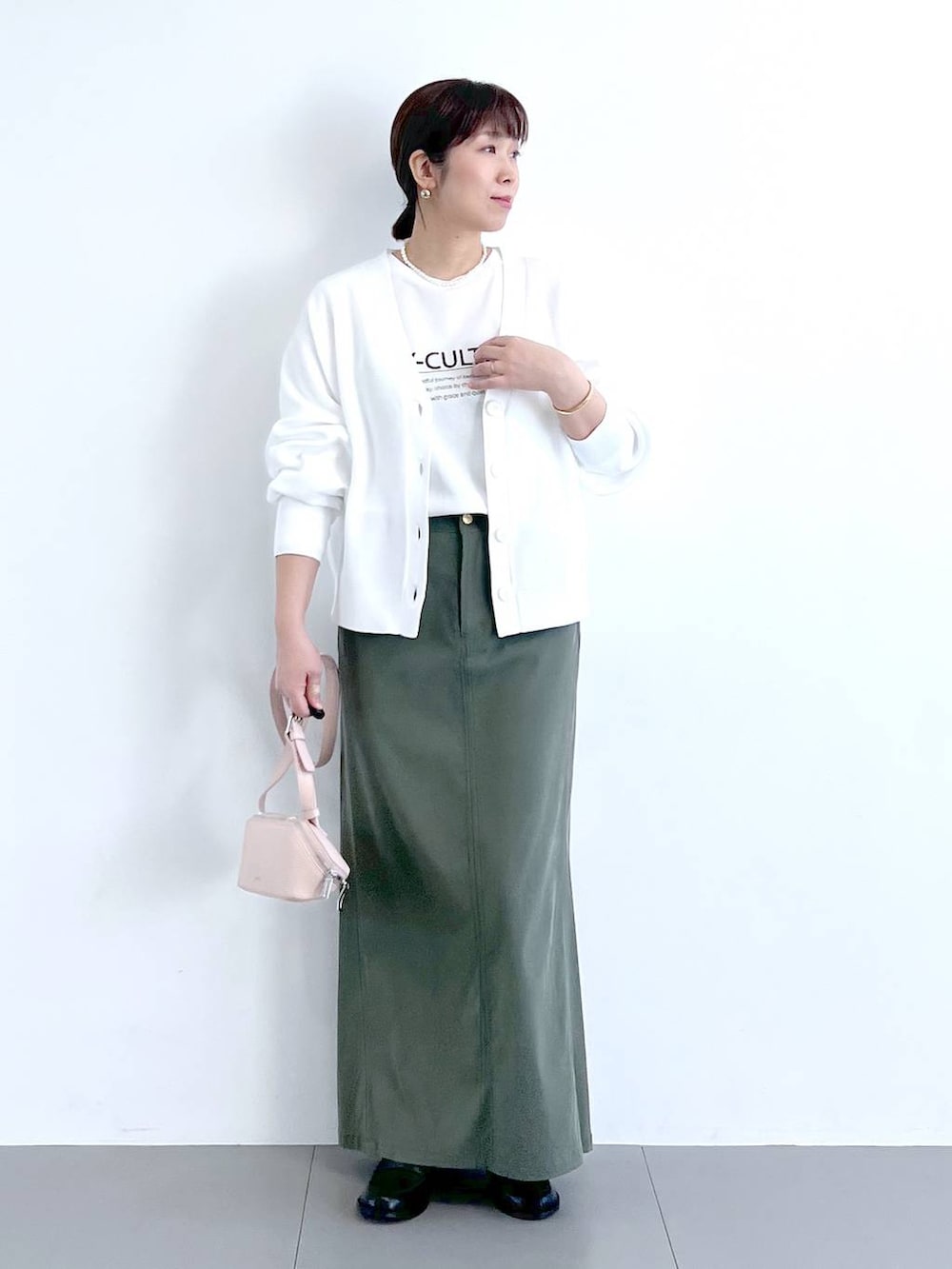 ホワイト系のTシャツ/カットソー、グリーン系のスカート、ピンク系のショルダーバッグを着用したレディースの冬コーディネートの4枚目の写真