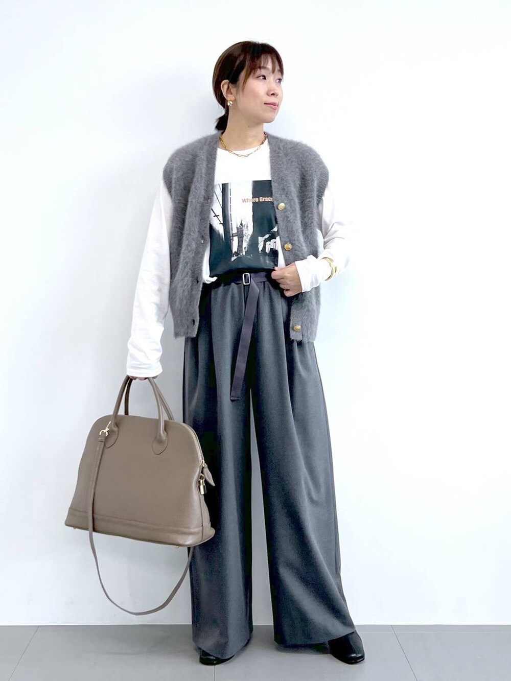 グレー系のスラックス、グレー系のベスト、ブラウン系のボストンバッグを着用したレディースの夏コーディネートの4枚目の写真