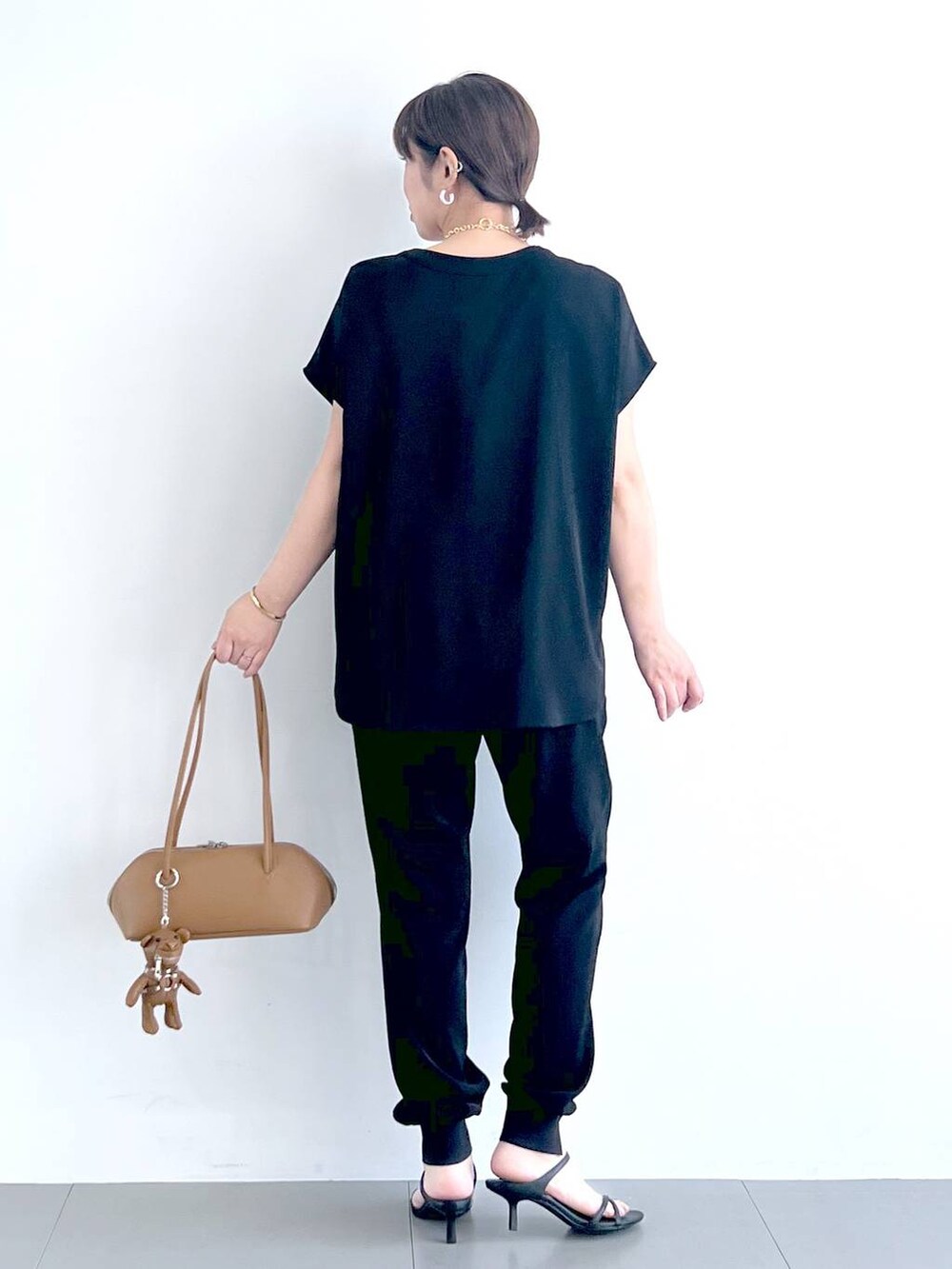 ブラウン系のハンドバッグ、ブラック系のシャツ/ブラウス、ブラック系のサンダルを着用したレディースの春コーディネートの8枚目の写真