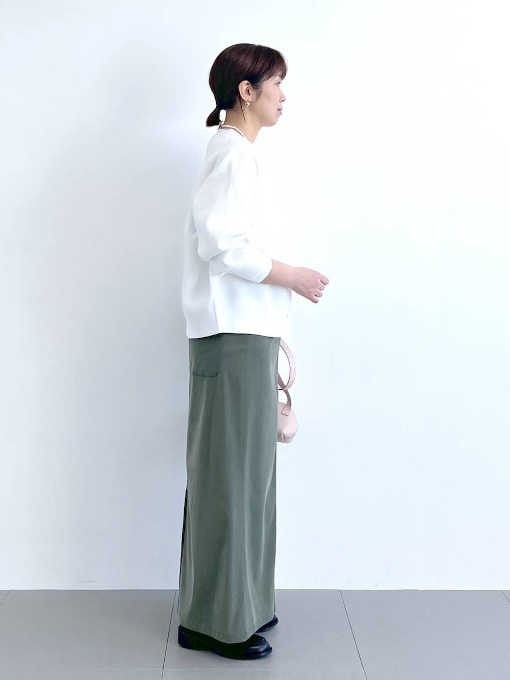 ホワイト系のTシャツ/カットソー、グリーン系のスカート、ピンク系のショルダーバッグを着用したレディースの冬コーディネートの6枚目の写真