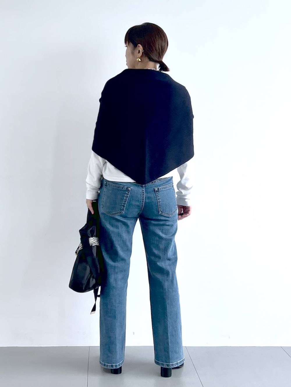 ブルー系のデニムパンツ、その他のショルダーバッグ、ブラック系のブーツを着用したレディースの秋コーディネートの6枚目の写真