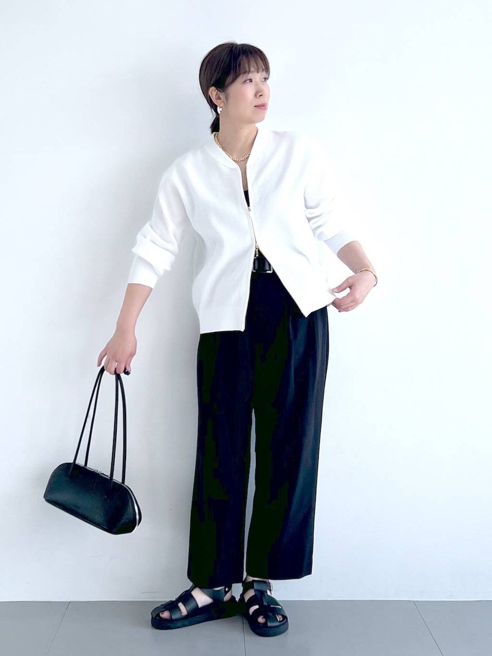 ブラック系のその他パンツ、ブラック系のハンドバッグ、ホワイト系のカーディガン/ボレロを着用したレディースの春コーディネートの7枚目の写真