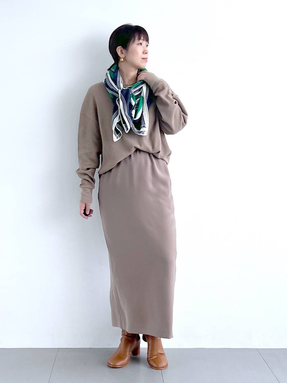 ブラウン系のスカート、イエロー系のブーツ、その他のトートバッグを着用したレディースの秋コーディネートの3枚目の写真