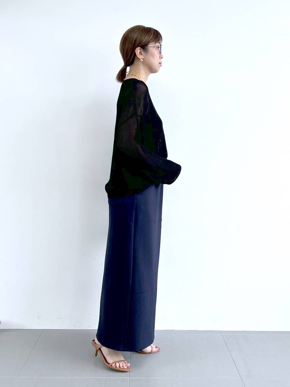 ブラウン系のサンダル、ブラック系のニット/セーター、ブルー系のスカートを着用したレディースの夏コーディネートの6枚目の写真