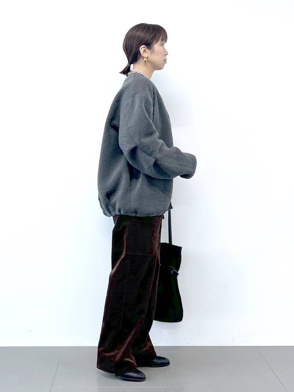 ブラック系のブーツ、グレー系のブルゾン、シルバー系のネックレスを着用したレディースの秋コーディネートの6枚目の写真