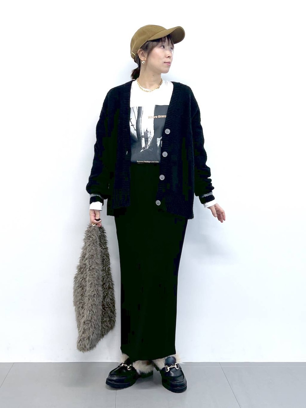 ブラック系のスカート、ブラック系のカーディガン/ボレロ、ブラウン系のハンドバッグを着用したレディースの秋コーディネートの8枚目の写真