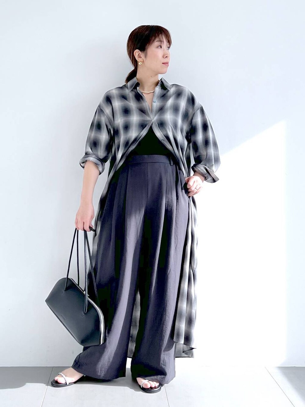 ブラック系のトートバッグ、グレー系のシャツワンピース、グレー系のその他パンツを着用したレディースの春コーディネートの5枚目の写真