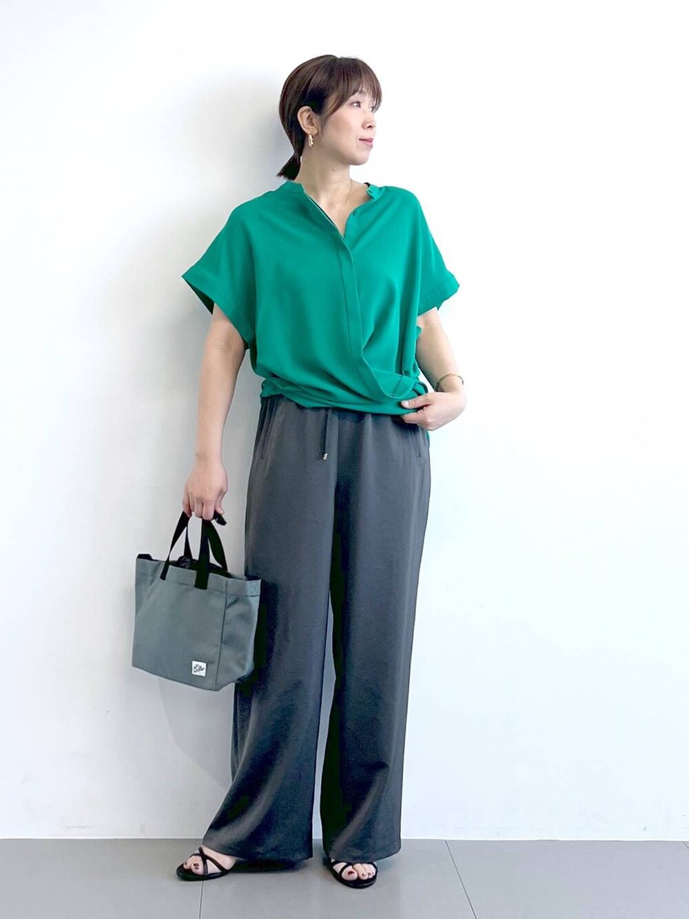グレー系のその他パンツ、ブラック系のサンダル、ブラック系のショルダーバッグを着用したレディースの春コーディネートの4枚目の写真