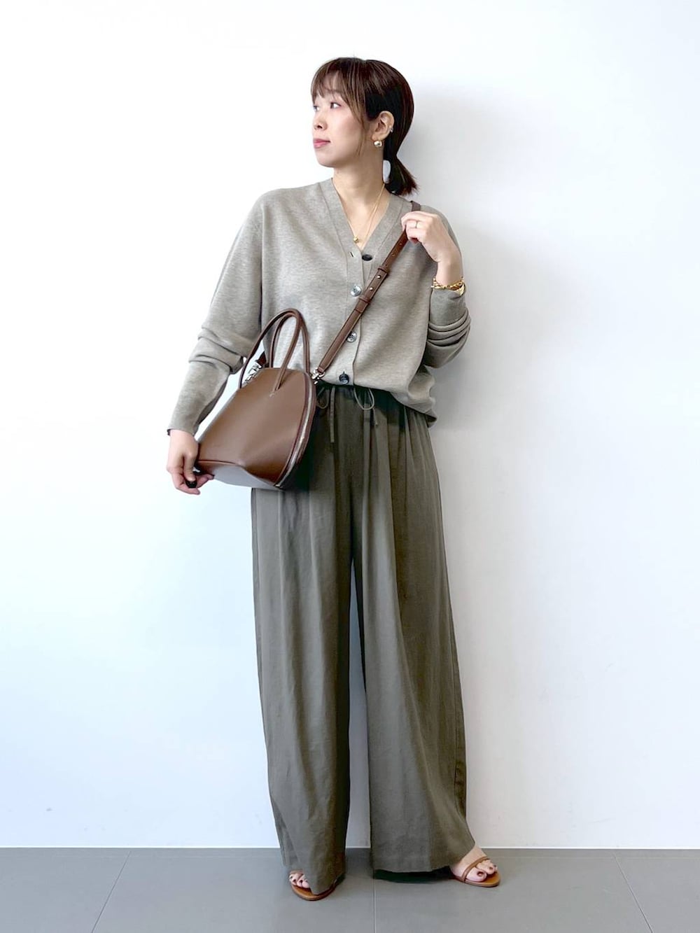 ブラウン系のその他パンツ、ベージュ系のカーディガン/ボレロ、ブラウン系のサンダルを着用したレディースの夏コーディネートの4枚目の写真