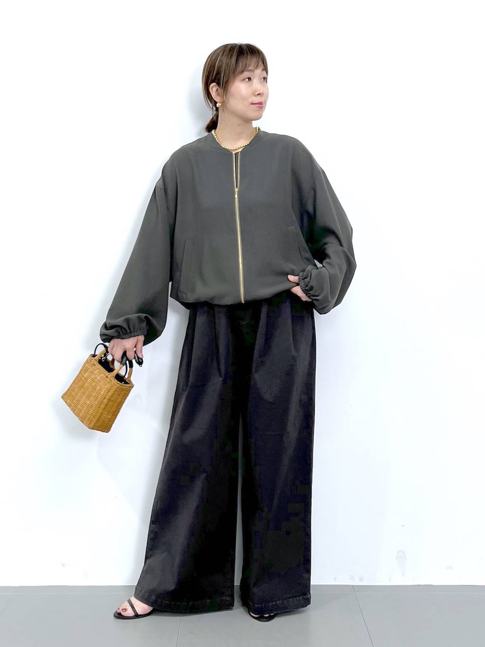 グレー系のブルゾン、ブラック系のショルダーバッグ、ブラック系のサンダルを着用したレディースの秋コーディネートの5枚目の写真