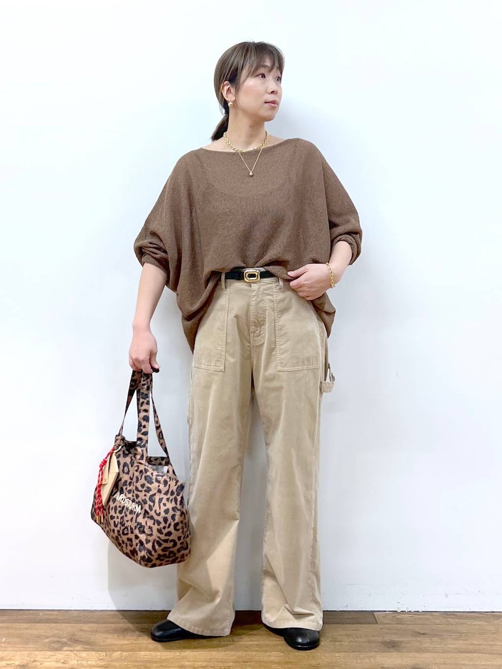 ブラウン系のニット/セーター、ブラウン系のトートバッグ、その他のピアス（両耳用）を着用したレディースの夏コーディネートの2枚目の写真