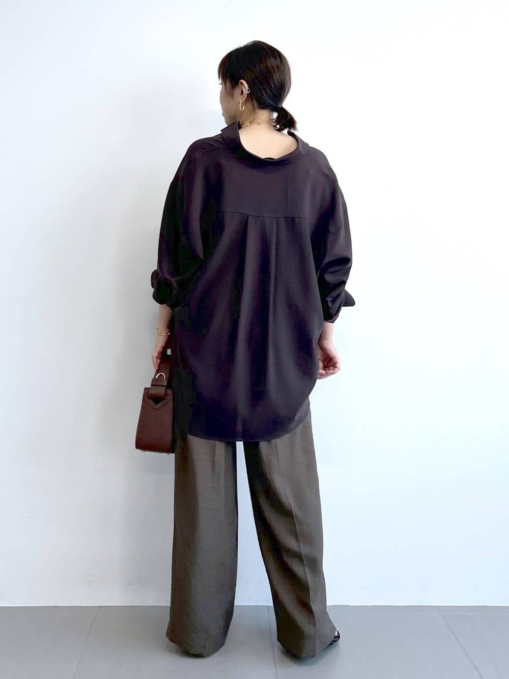 ブラウン系のハンドバッグ、ブラック系のサンダル、ブラウン系のシャツ/ブラウスを着用したレディースの夏コーディネートの7枚目の写真