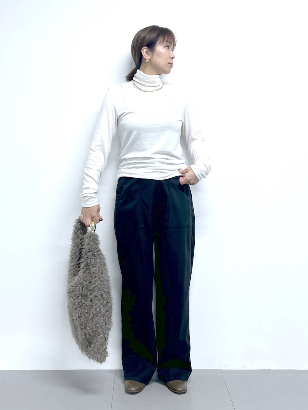 ブラック系のチノパンツ、ホワイト系のTシャツ/カットソー、ブラウン系のハンドバッグを着用したレディースの秋コーディネートの4枚目の写真