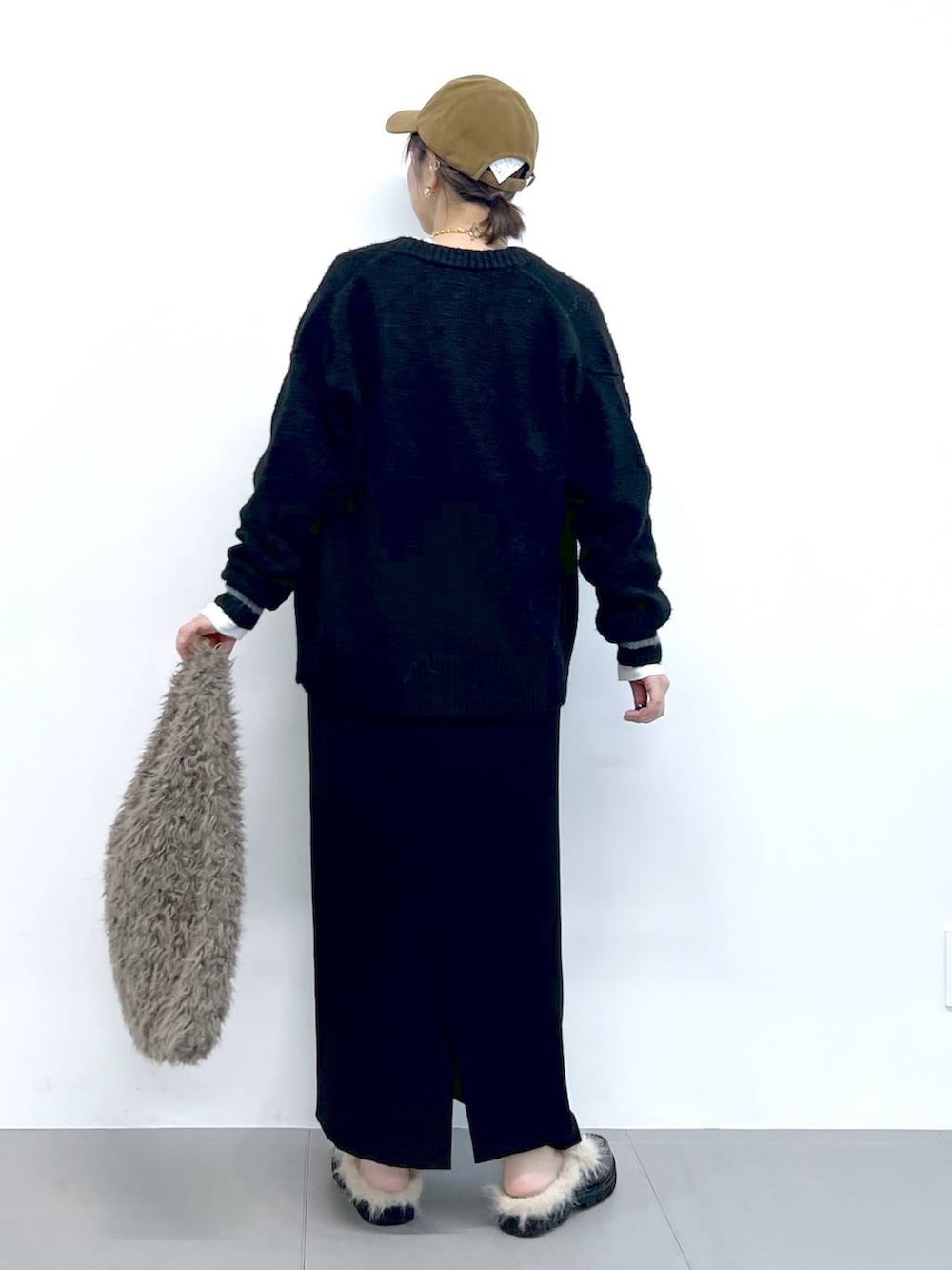 ブラック系のスカート、ブラック系のカーディガン/ボレロ、ブラウン系のハンドバッグを着用したレディースの秋コーディネートの10枚目の写真