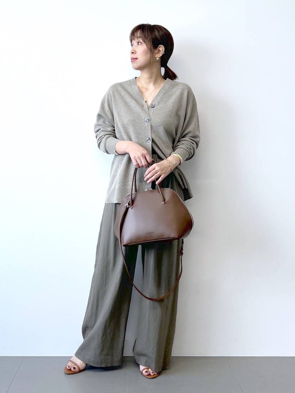 ブラウン系のその他パンツ、ベージュ系のカーディガン/ボレロ、ブラウン系のサンダルを着用したレディースの夏コーディネートの5枚目の写真