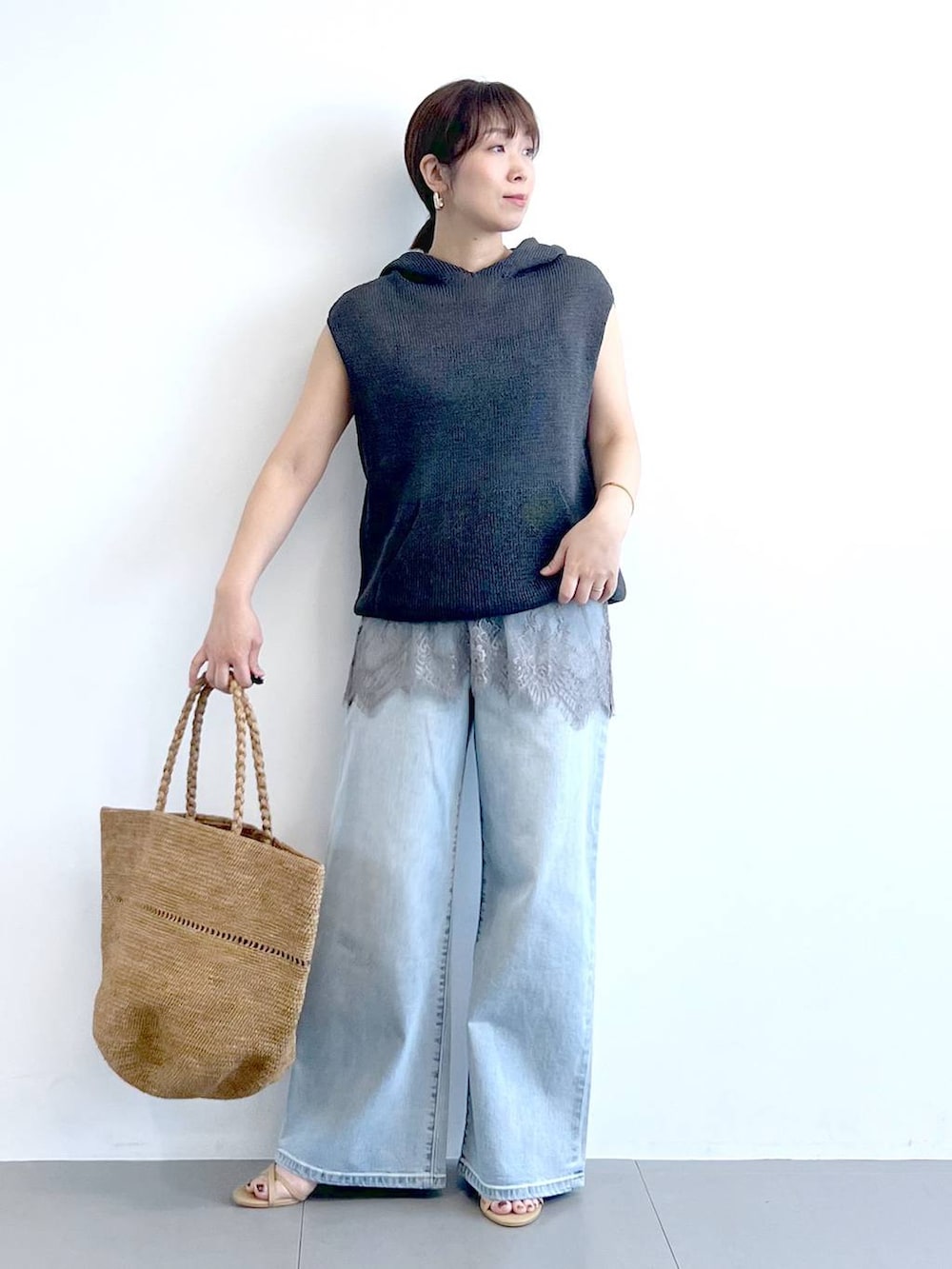 ブルー系のデニムパンツ、グレー系のキャミソール、グレー系のニット/セーターを着用したレディースの春コーディネートの5枚目の写真