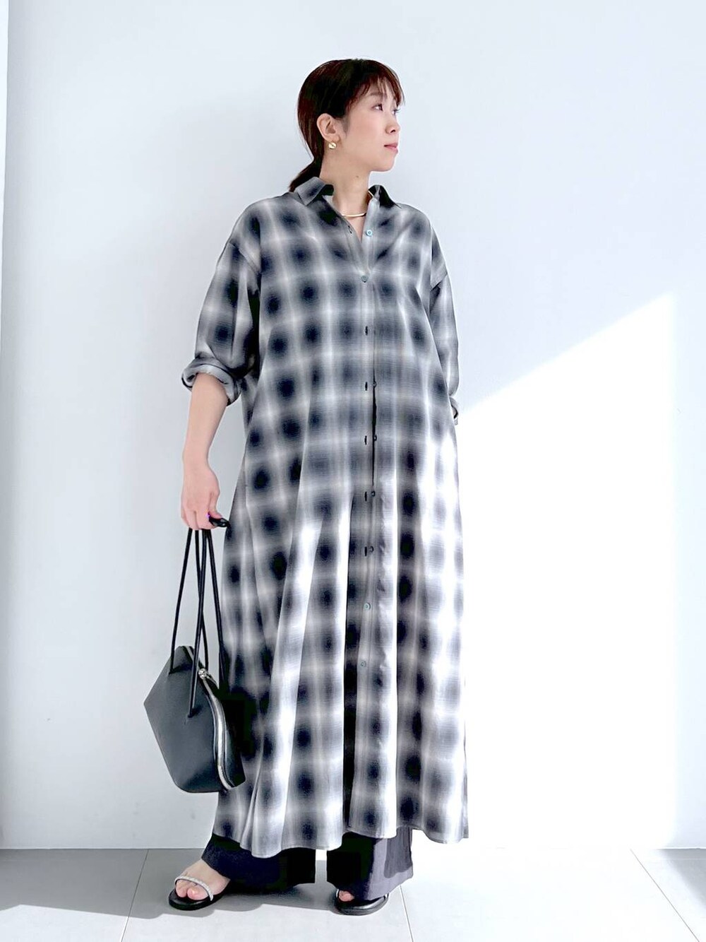 ブラック系のトートバッグ、グレー系のシャツワンピース、グレー系のその他パンツを着用したレディースの春コーディネートの3枚目の写真