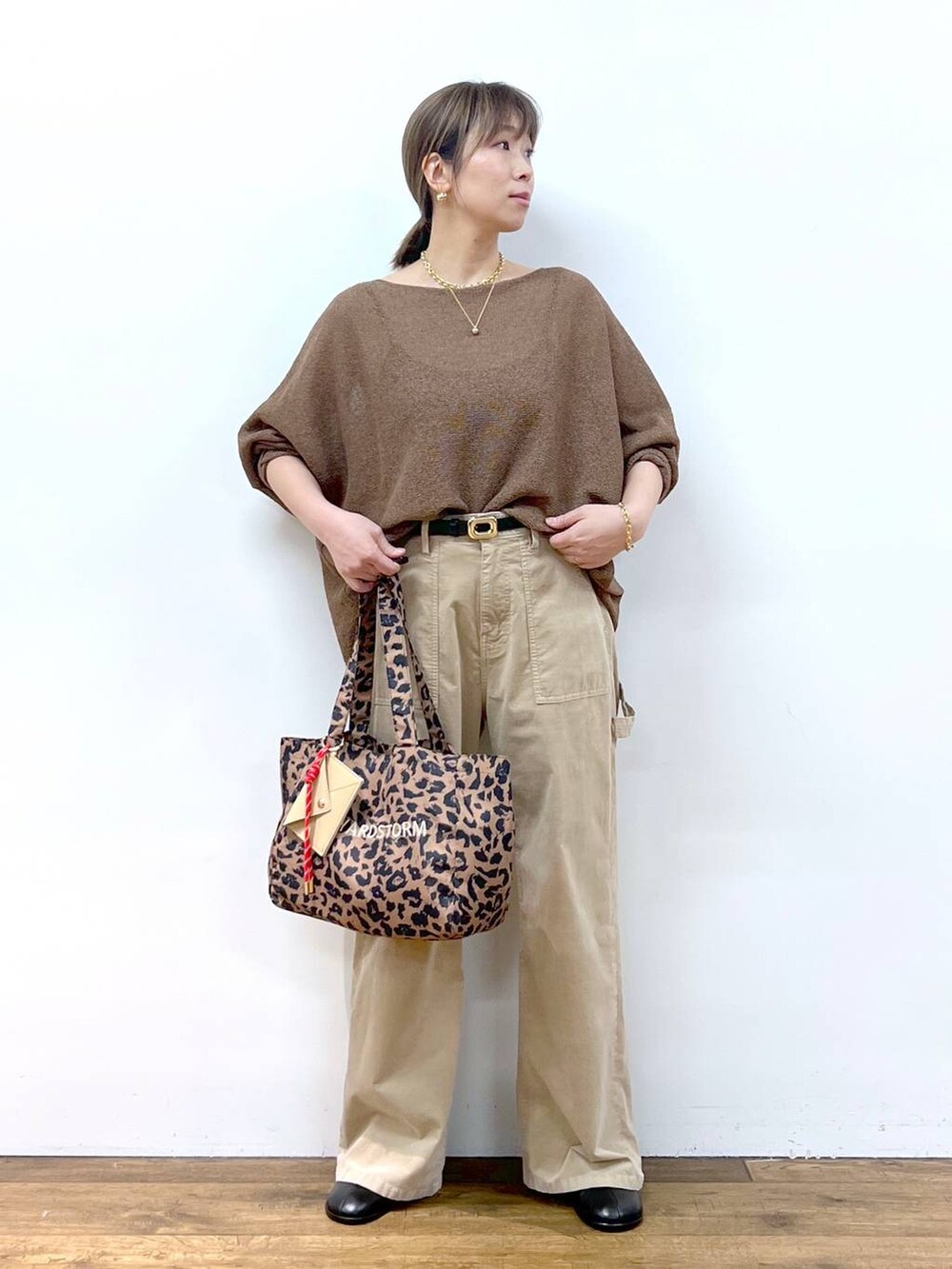 ブラウン系のニット/セーター、ブラウン系のトートバッグ、その他のピアス（両耳用）を着用したレディースの夏コーディネートの3枚目の写真