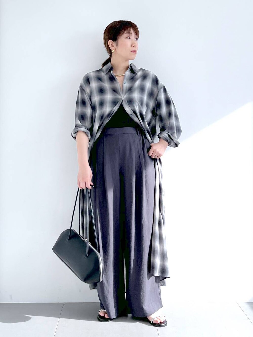 ブラック系のトートバッグ、グレー系のシャツワンピース、グレー系のその他パンツを着用したレディースの春コーディネートの7枚目の写真