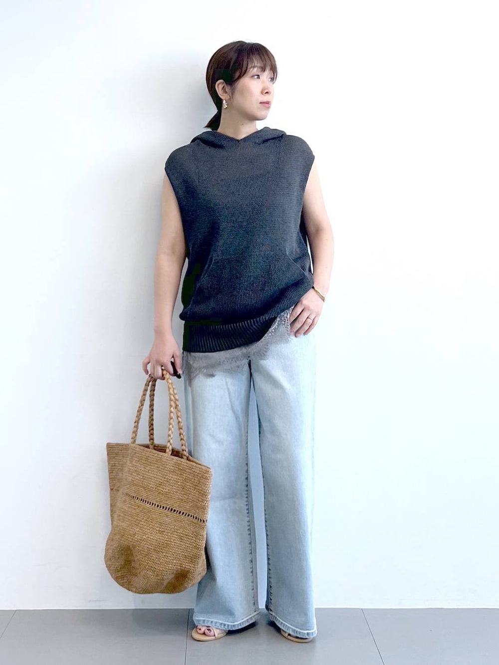 ブルー系のデニムパンツ、グレー系のキャミソール、グレー系のニット/セーターを着用したレディースの春コーディネートの3枚目の写真