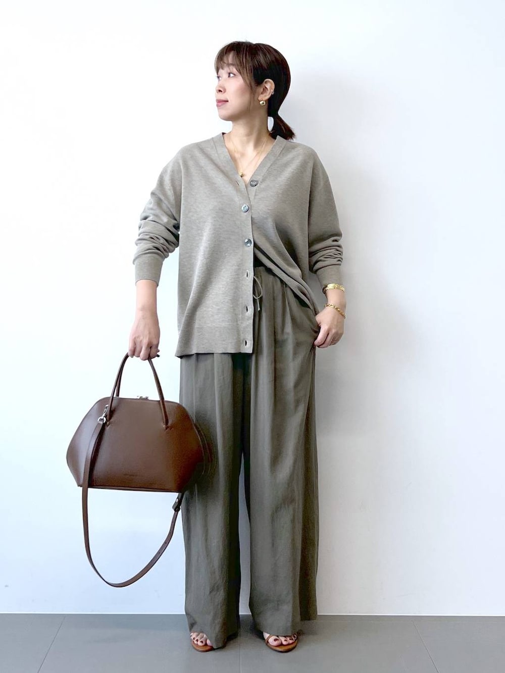 ブラウン系のその他パンツ、ベージュ系のカーディガン/ボレロ、ブラウン系のサンダルを着用したレディースの夏コーディネートの2枚目の写真