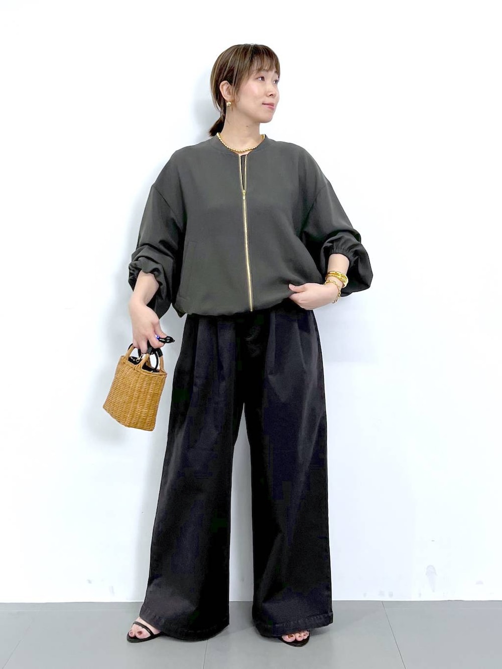 グレー系のブルゾン、ブラック系のショルダーバッグ、ブラック系のサンダルを着用したレディースの秋コーディネートの4枚目の写真