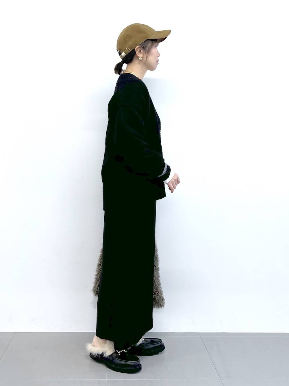 ブラック系のスカート、ブラック系のカーディガン/ボレロ、ブラウン系のハンドバッグを着用したレディースの秋コーディネートの9枚目の写真