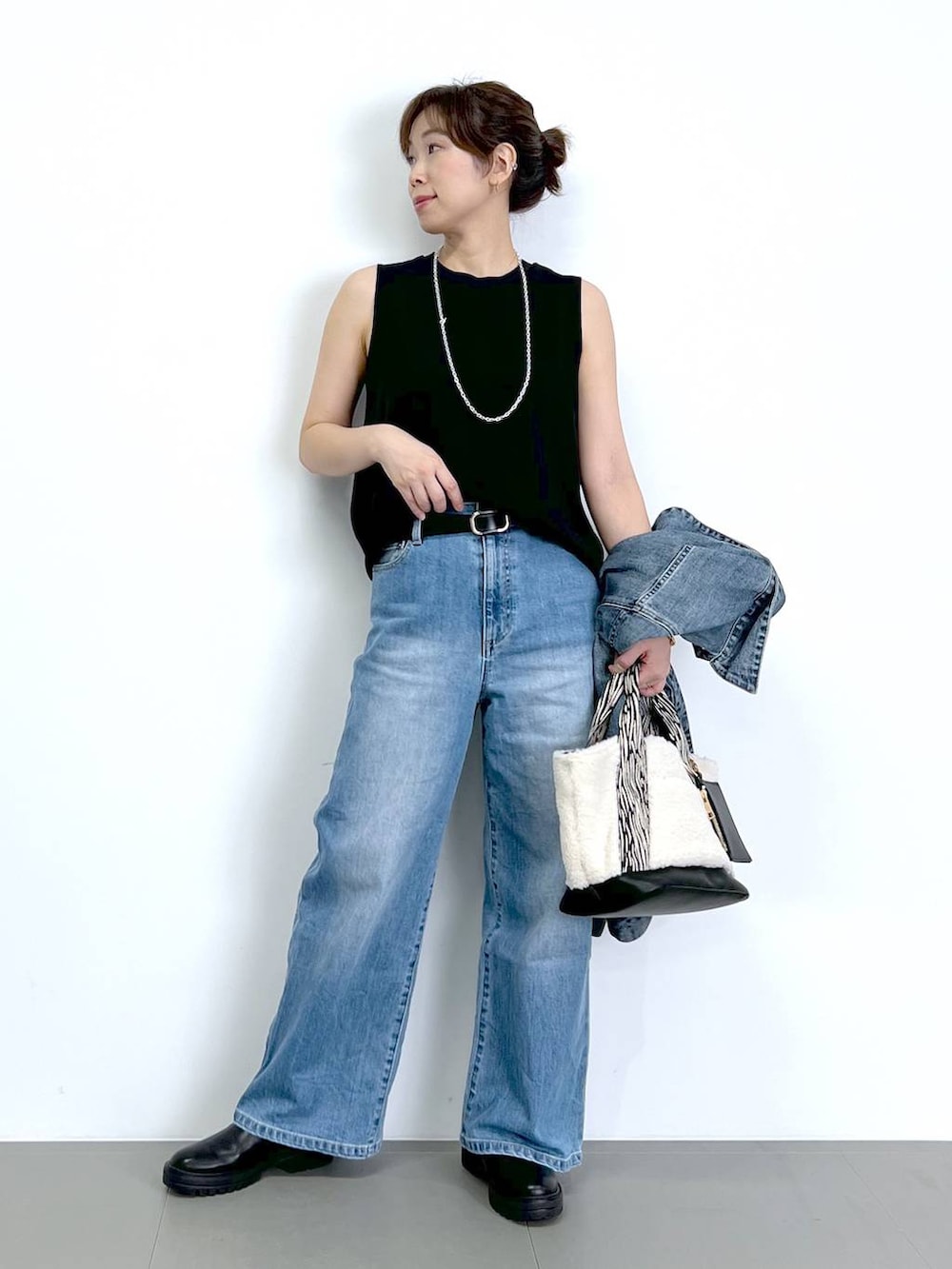 ブルー系のデニムパンツ、ブラック系のTシャツ/カットソー、ブラック系のブーツを着用したレディースの秋コーディネートの8枚目の写真