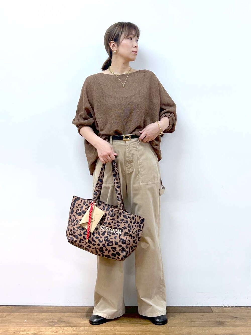 ブラウン系のニット/セーター、ブラウン系のトートバッグ、その他のピアス（両耳用）を着用したレディースの夏コーディネートの4枚目の写真