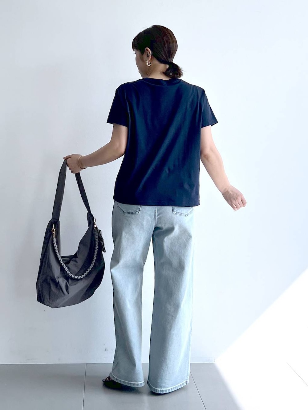 ブルー系のデニムパンツ、グレー系のショルダーバッグ、ブラック系のサンダルを着用したレディースの夏コーディネートの8枚目の写真
