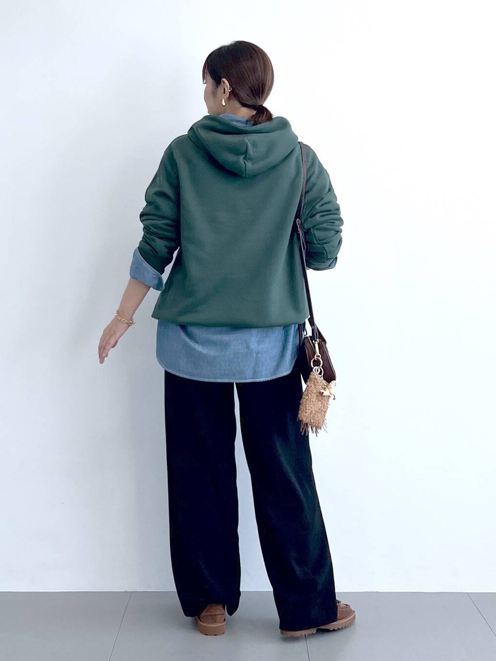 ブラック系のスラックス、グリーン系のパーカー、ブラウン系のショルダーバッグを着用したレディースの秋コーディネートの9枚目の写真