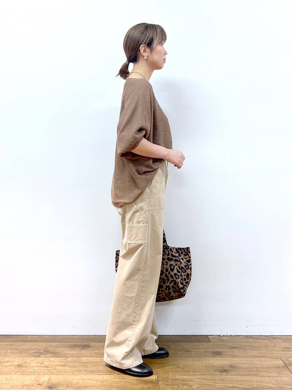 ブラウン系のニット/セーター、ブラウン系のトートバッグ、その他のピアス（両耳用）を着用したレディースの夏コーディネートの8枚目の写真