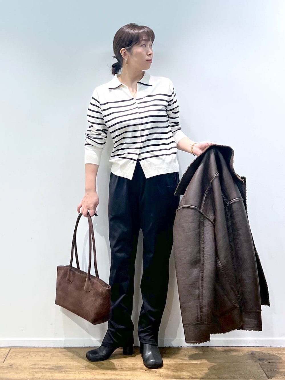ブラック系のその他パンツ、ホワイト系のニット/セーター、その他のピアス(両耳用)を着用したレディースの秋コーディネートの7枚目の写真