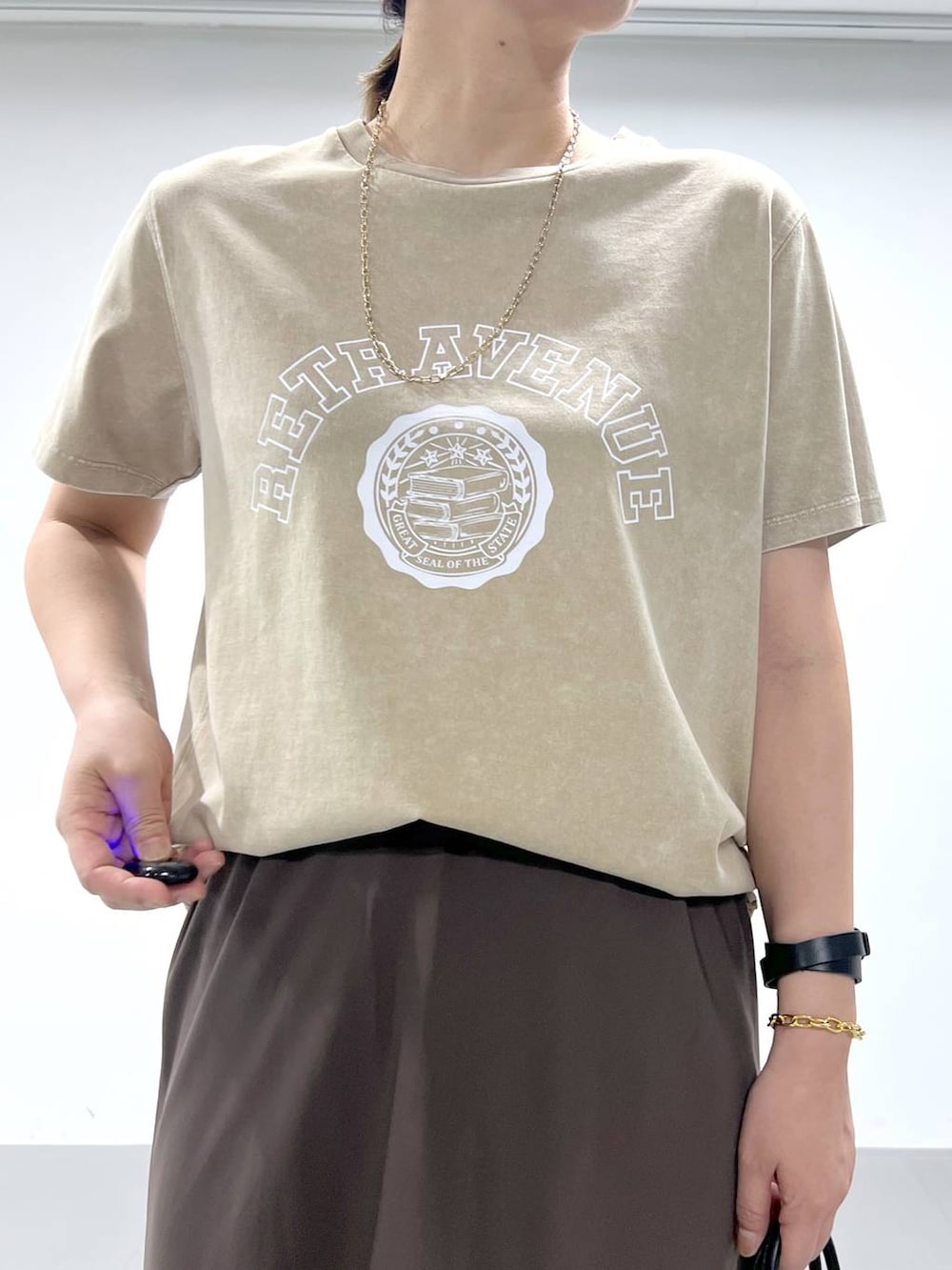 ブラック系のトートバッグ、ベージュ系のサンダル、ベージュ系のTシャツ/カットソーを着用したレディースの夏コーディネートの3枚目の写真