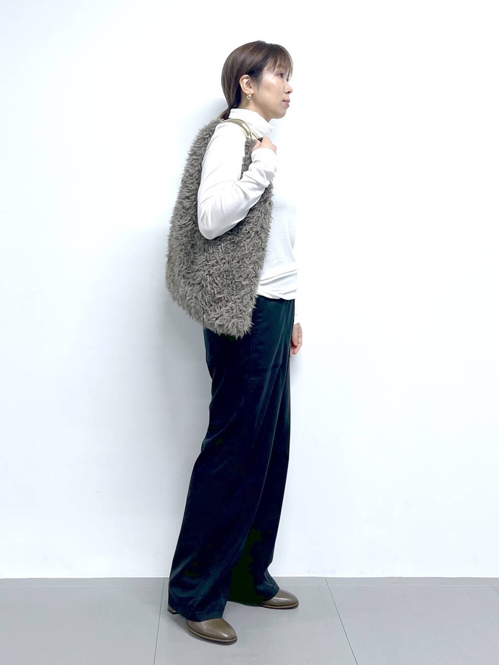 ブラック系のチノパンツ、ホワイト系のTシャツ/カットソー、ブラウン系のハンドバッグを着用したレディースの秋コーディネートの7枚目の写真