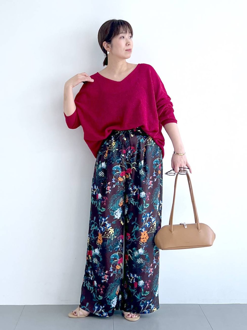 ブラウン系のその他パンツ、ブラウン系のハンドバッグ、レッド系のニット/セーターを着用したレディースの春コーディネートの2枚目の写真