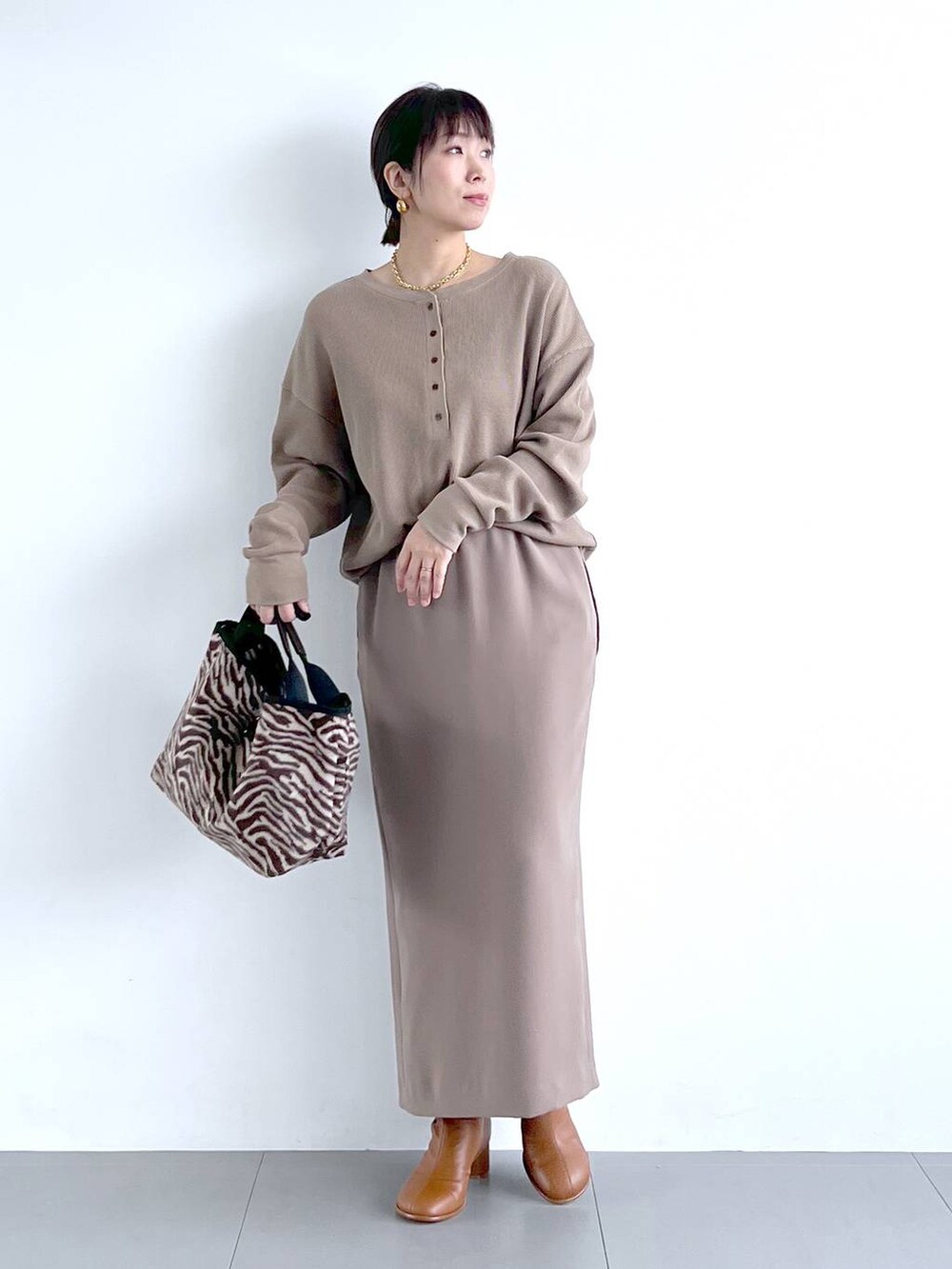 ブラウン系のスカート、イエロー系のブーツ、その他のトートバッグを着用したレディースの秋コーディネートの6枚目の写真