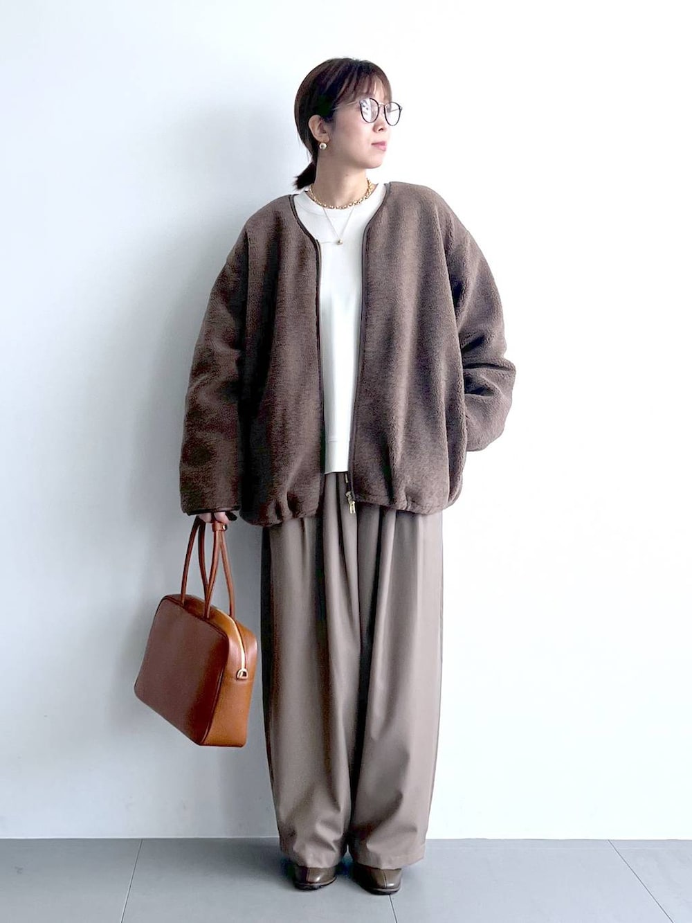 ベージュ系のその他パンツ、イエロー系のハンドバッグ、ブラウン系のブーツを着用したレディースの秋コーディネートの7枚目の写真