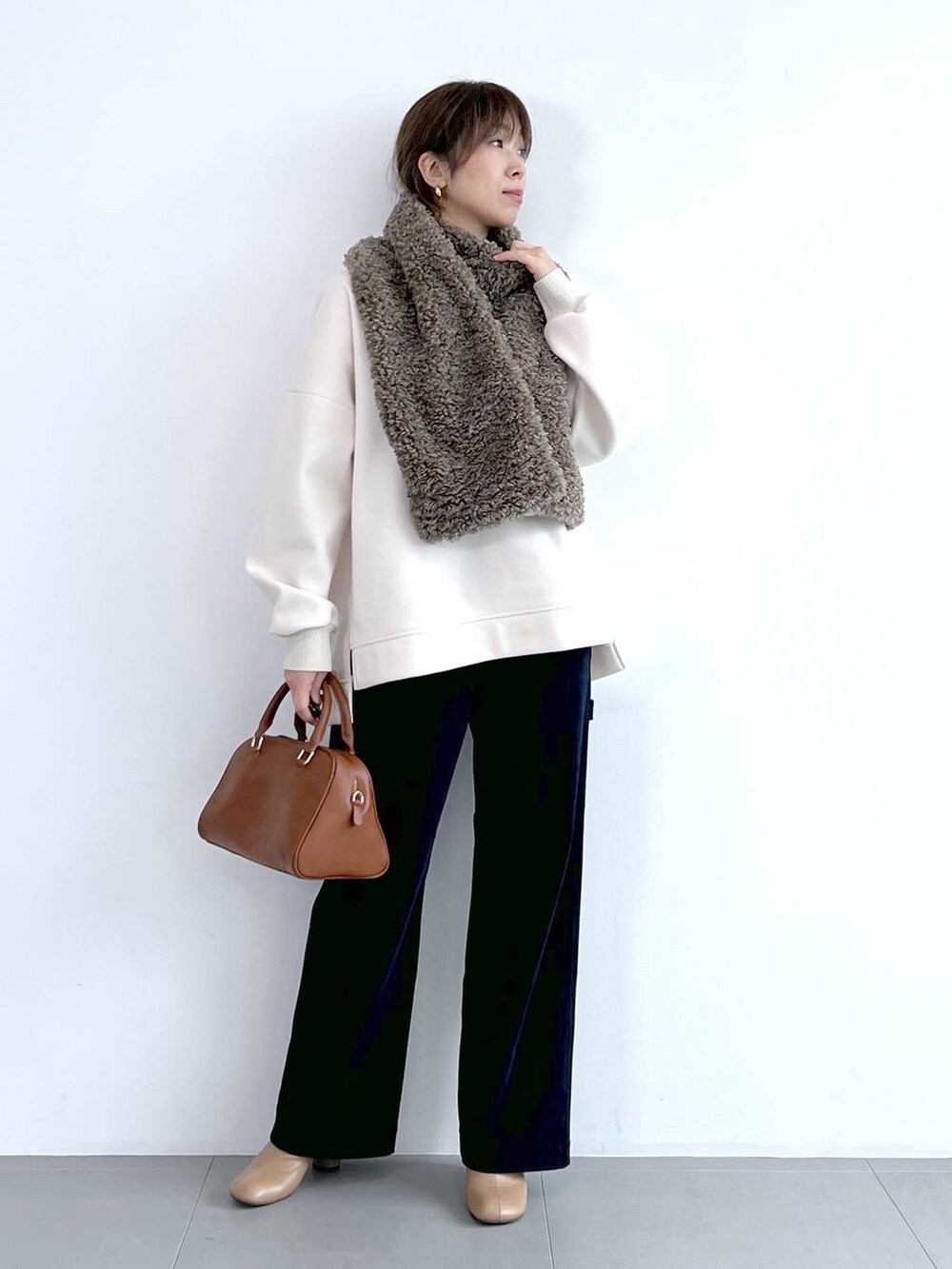 ブルー系のその他パンツ、イエロー系のボストンバッグ、ベージュ系のブーツを着用したレディースの秋コーディネートの6枚目の写真