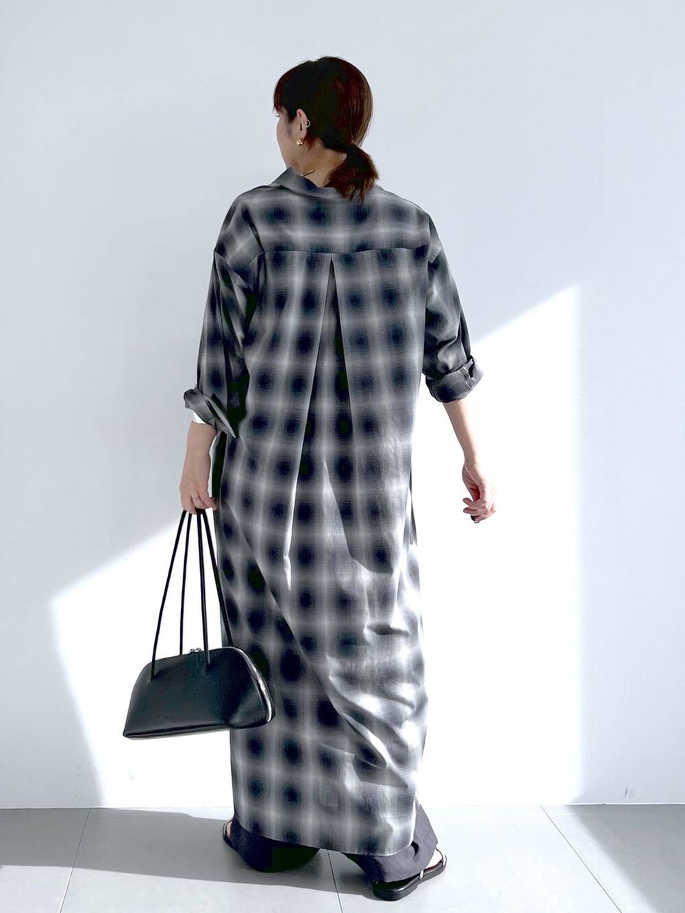 ブラック系のトートバッグ、グレー系のシャツワンピース、グレー系のその他パンツを着用したレディースの春コーディネートの9枚目の写真