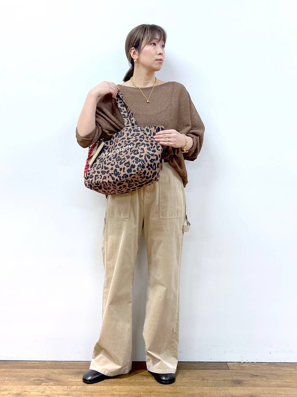 ブラウン系のニット/セーター、ブラウン系のトートバッグ、その他のピアス（両耳用）を着用したレディースの夏コーディネートの6枚目の写真