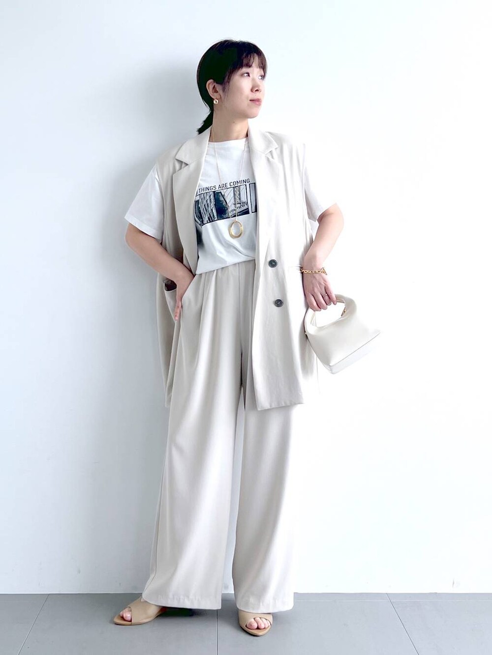 ホワイト系のベスト、ホワイト系のその他パンツ、ホワイト系のTシャツ/カットソーを着用したレディースの春コーディネートの2枚目の写真