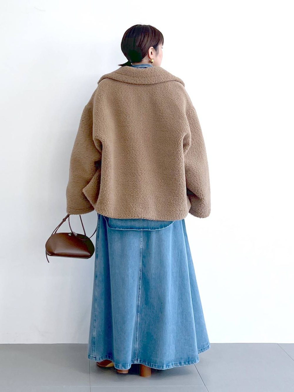 イエロー系のピーコート、ブルー系のシャツ/ブラウス、ブラウン系のショルダーバッグを着用したレディースの秋コーディネートの7枚目の写真