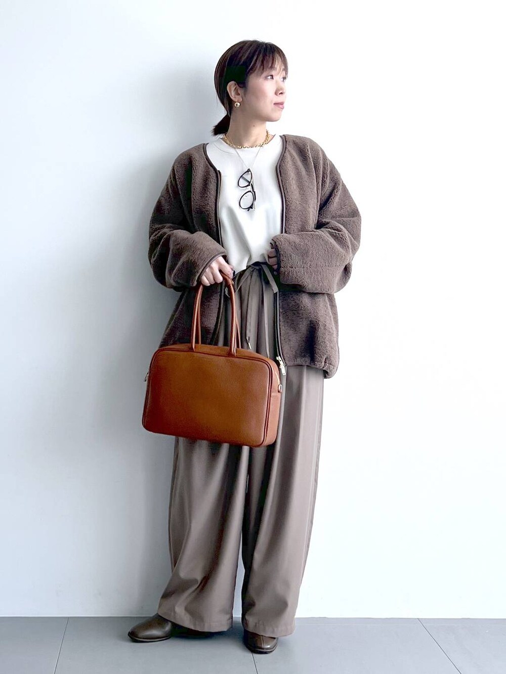 ベージュ系のその他パンツ、イエロー系のハンドバッグ、ブラウン系のブーツを着用したレディースの秋コーディネートの5枚目の写真