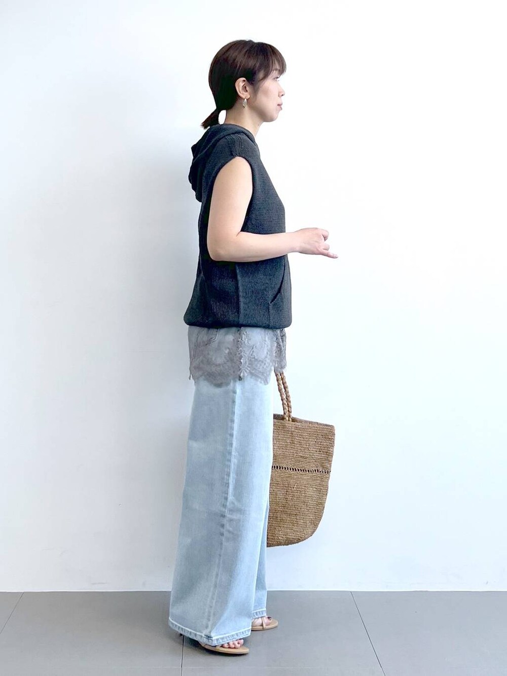 ブルー系のデニムパンツ、グレー系のキャミソール、グレー系のニット/セーターを着用したレディースの春コーディネートの6枚目の写真