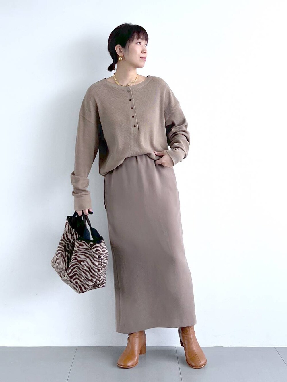 ブラウン系のスカート、イエロー系のブーツ、その他のトートバッグを着用したレディースの秋コーディネートの8枚目の写真