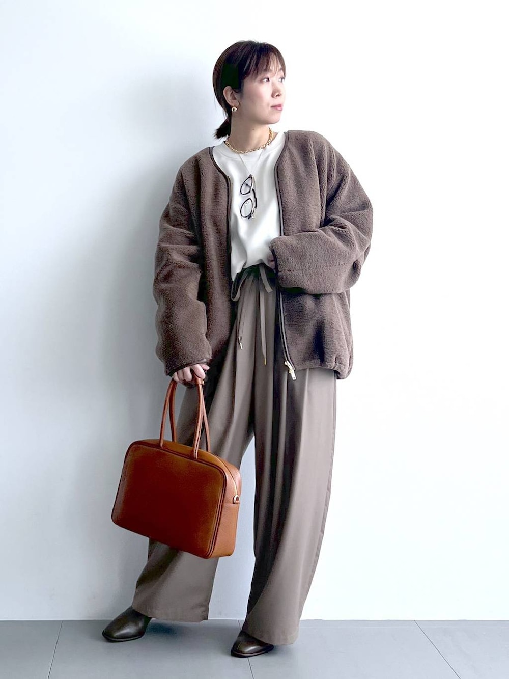 ベージュ系のその他パンツ、イエロー系のハンドバッグ、ブラウン系のブーツを着用したレディースの秋コーディネートの3枚目の写真